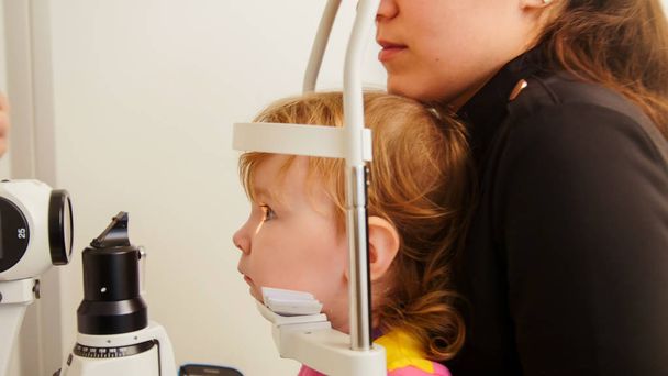 Badania przesiewowe wzroku dziecka z wykorzystaniem aparatury okulistycznej - Zdjęcie, obraz