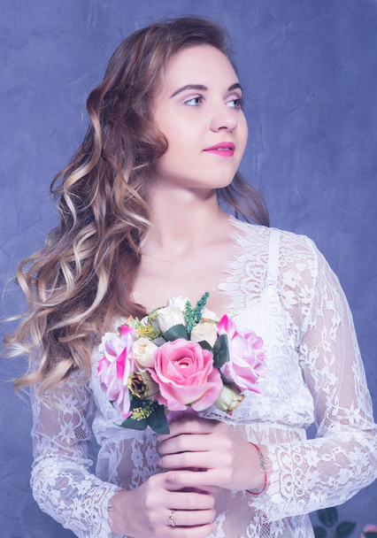 schöne Mädchen in einem weißen peignoir mit einem Strauß Blumen - Foto, Bild