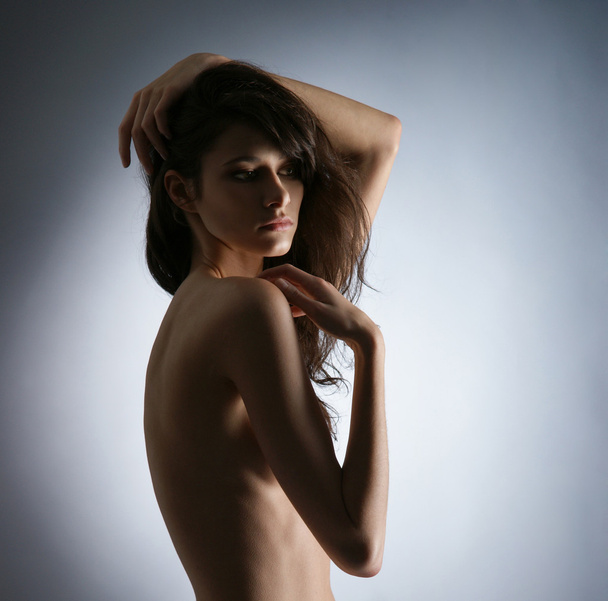 Young naked woman over grey background - Фото, изображение