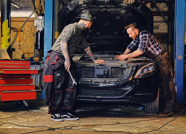 zwei Mechaniker reparieren den Motor des Autos - Foto, Bild
