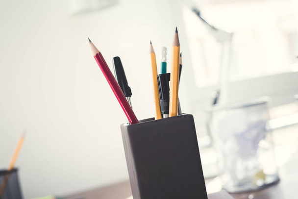 Олівці та маркери в тримачі для ручок
  - Фото, зображення