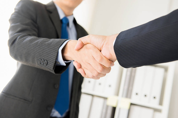Бизнесмены пожимают друг другу руки в офисе
 - Фото, изображение