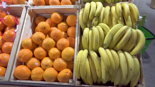 Bananen en sinaasappelen in een supermarkt. - Video