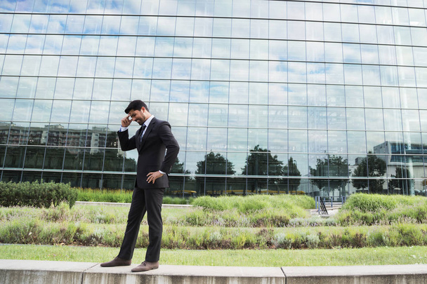 Successful businessman or worker standing in suit near office building - Foto, Imagen