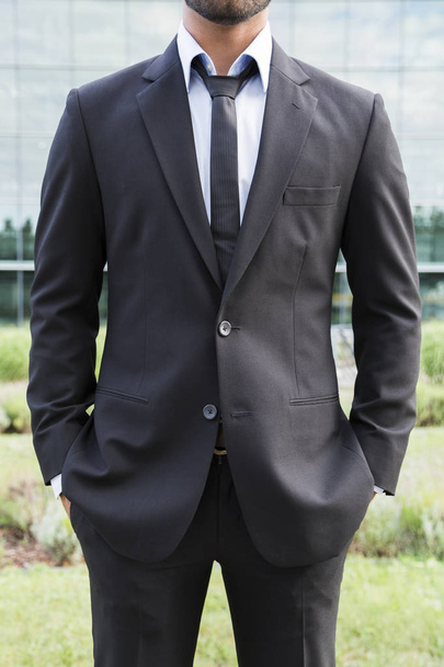 Businessman or worker standing in suit near office building - 写真・画像