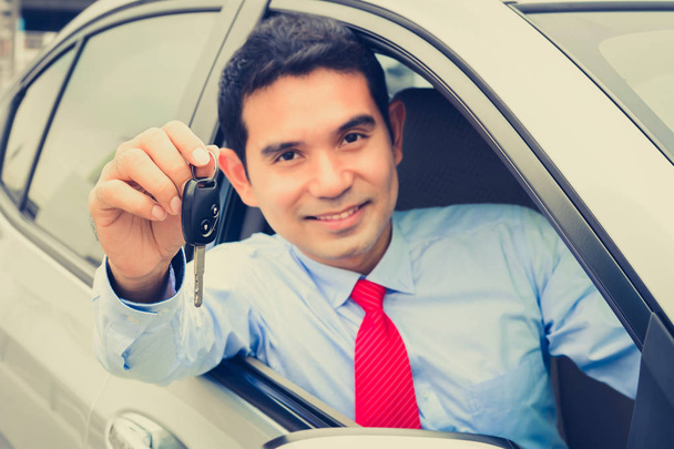 sonriendo asiático hombre de negocios como un conductor mostrando coche llave
  - Foto, Imagen