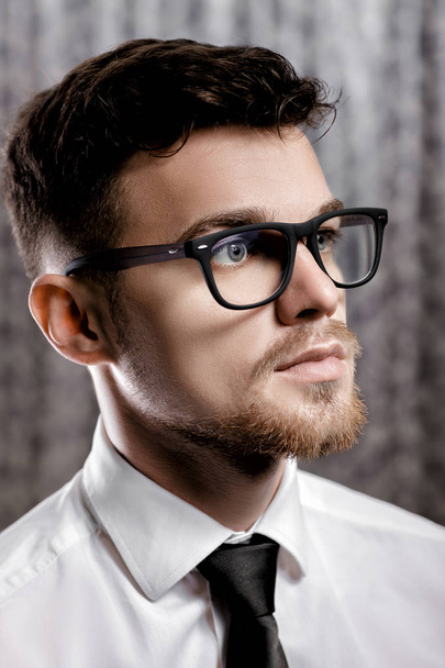 Szemüveg és fehér inget, szürke háttér, csinos, fiatal férfi portréja - Fotó, kép