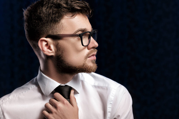 Profileof handsome young man with glasses and white shirt on dark background - Valokuva, kuva