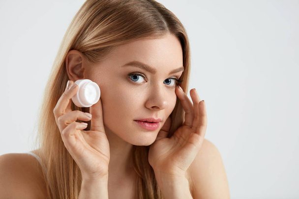 Beauty Face Cosmetics. Beautiful Female Putting Cream Under Eyes - Foto, imagen