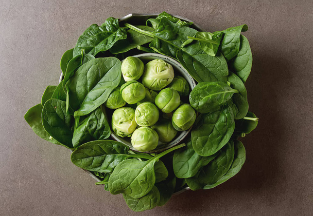 Washed fresh mini spinach and Brussels sprouts. Dark background. - Foto, afbeelding