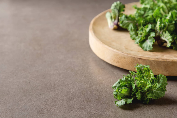 Fresh kale cabbage on a wooden board. Dark gray background. - Photo, image