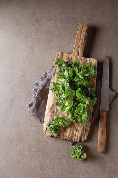 Fresh kale cabbage on a wooden board. Dark gray background. - Photo, Image