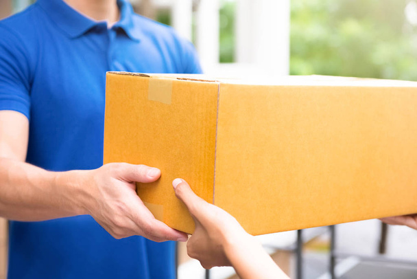 Uomo di consegna in uniforme blu che consegna scatole di pacchi al destinatario
 - Foto, immagini