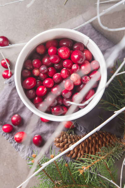 Red berries on a dark background. cranberries in a white bucket  - Фото, зображення