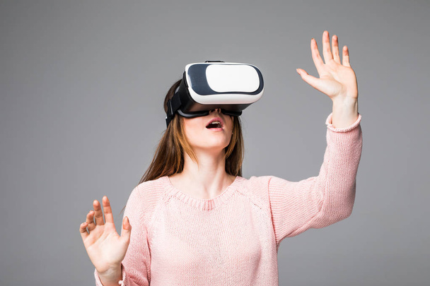 Mulher assistindo com dispositivo VR isolado em fundo cinza
 - Foto, Imagem
