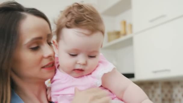 Mom holds her daughter in arms and plays with her. - Filmagem, Vídeo