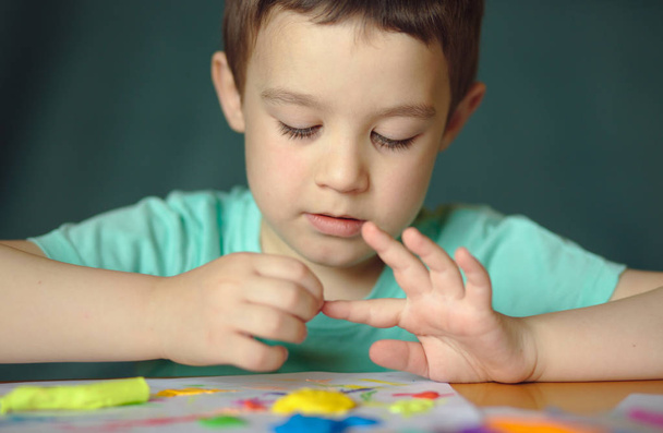 Boy playing with color play dough - Fotó, kép