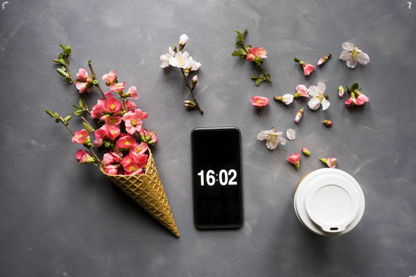 Flores em cone de sorvete com smartphone e café em cimento b
 - Foto, Imagem