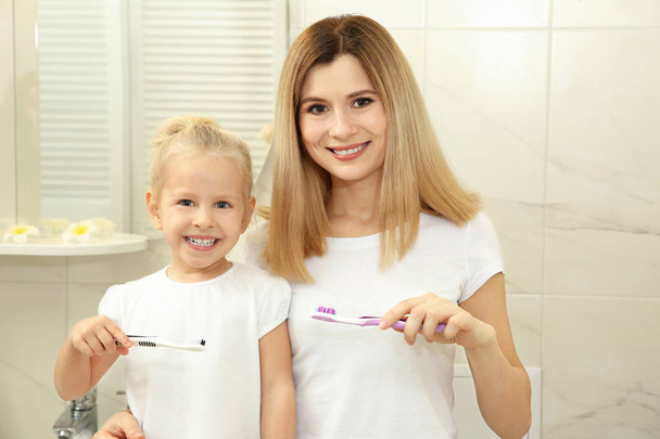 little girl with mother brushing teeth  - Fotó, kép