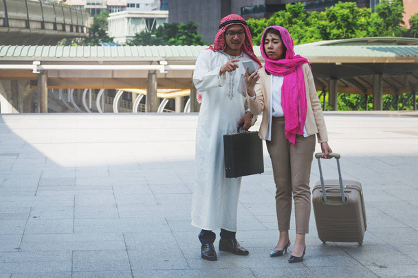 Emiraty mężczyzna i kobieta spaceru walizkę - Zdjęcie, obraz