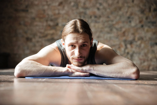 Happy strong sportsman in gym lies on floor - Zdjęcie, obraz