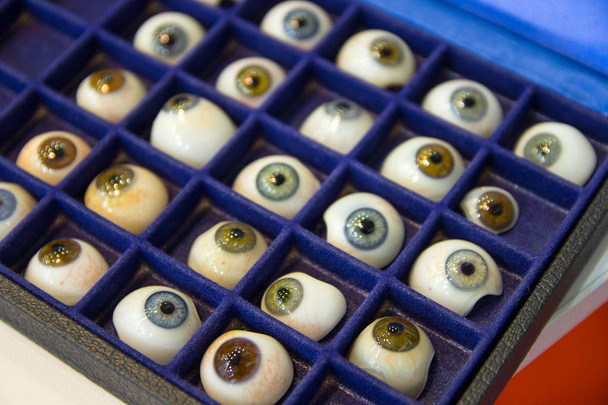 Prosthetic eyes with pupils of different colors on the stand. Medicine - Photo, Image
