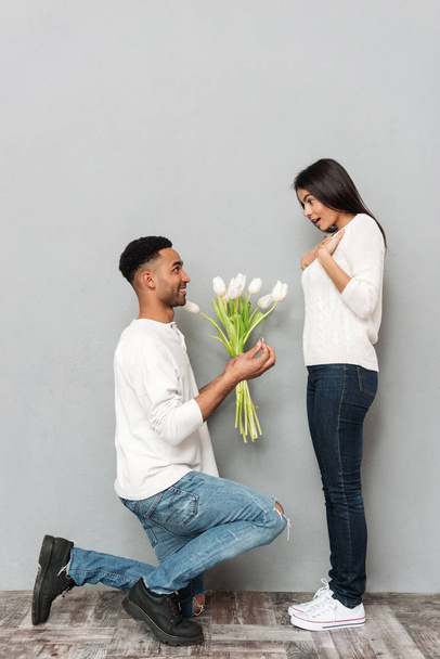 Man geeft een bloemen en trouwring aan vrouw. - Foto, afbeelding