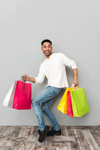 Smiling african man holding shopping bags - Fotografie, Obrázek