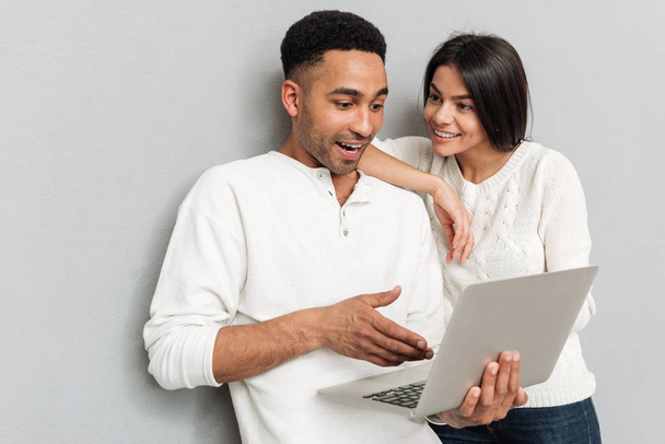 Smiling loving couple chatting by laptop computer. - Foto, Imagem