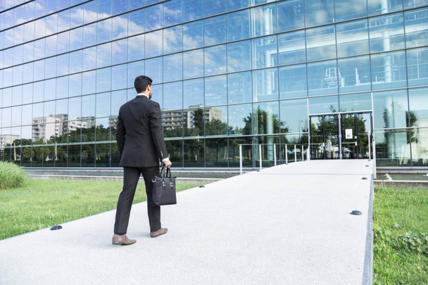 Empresário ou trabalhador em pé de terno perto de prédio de escritórios
 - Foto, Imagem