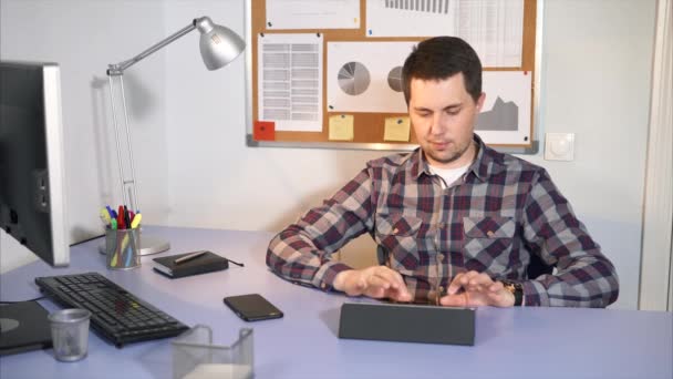 Administrativní pracovník kontroluje příchozí pošty na tabletu, sedí ve své kanceláři. - Záběry, video