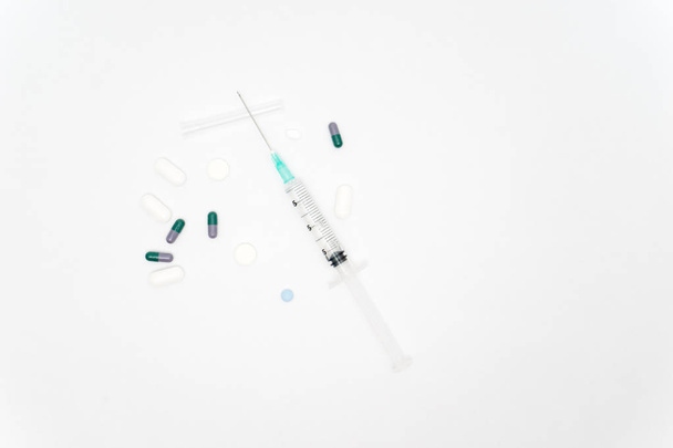 Медичний шприц і таблетки ізольовані на білому тлі
 - Фото, зображення
