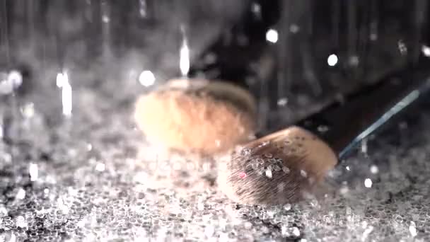 White sparkling glitter falling on makeup brushes on the black background, abstract slow motion - Footage, Video