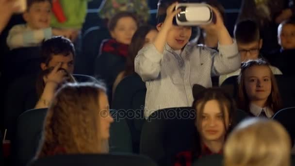 Dziatki, w kinie oglądając chłopca w okulary wirtualnej rzeczywistości. - Materiał filmowy, wideo