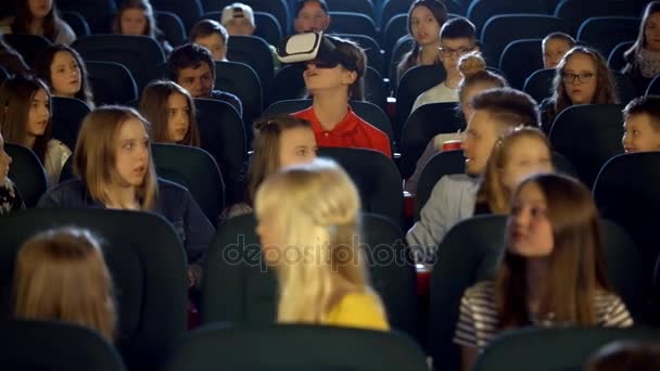 Niños pequeños adolescentes en el cine viendo a un niño con gafas de realidad virtual
. - Metraje, vídeo