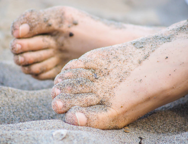Feet of one unrecognizable caucasian person resting in sand - 写真・画像