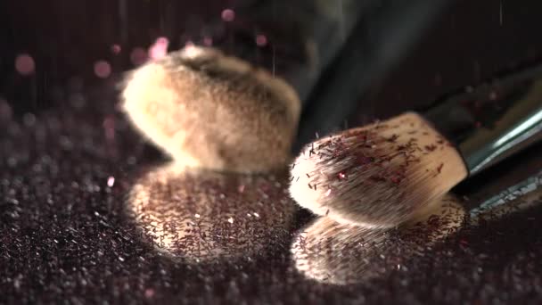 Pink glitter falling on the makeup brushes on the mirror on the black background, slow motion - Filmagem, Vídeo