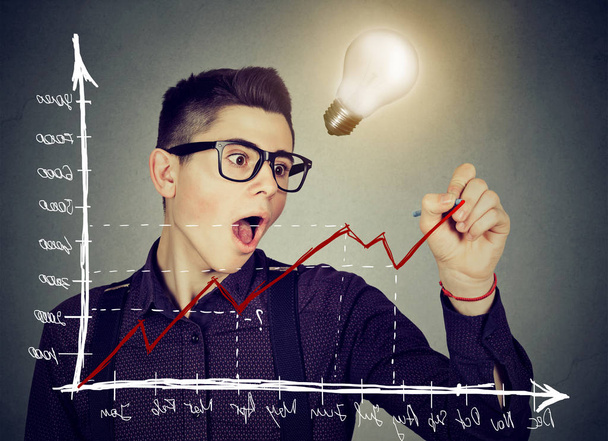 business man charting a positive trend graph has bright idea  - Фото, изображение