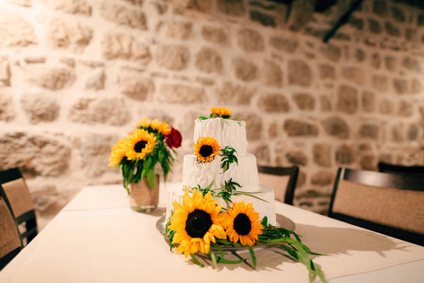 Bruidstaart, versierd met bloemen van zonnebloem. - Foto, afbeelding