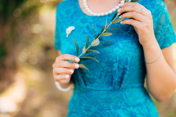 Rama de olivo en manos femeninas. Las manos de la novia. Boda en Mon
 - Foto, Imagen