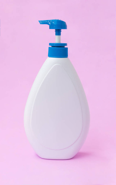 Botella de loción blanca sobre fondo rosa, concepto de cuidado de la piel de belleza
 - Foto, imagen
