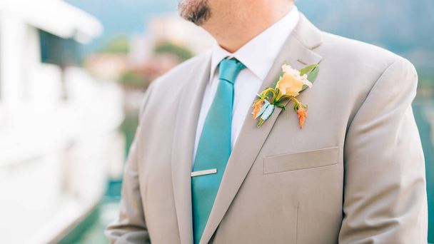 De bruidegom met een baard corsages op de revers van een lichte sweater - Foto, afbeelding