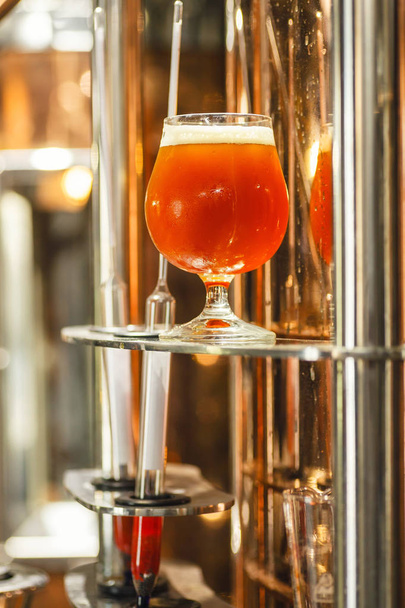 Un vaso de cerveza en una tetera de cobre
 - Foto, imagen
