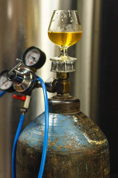 Un vaso de cerveza en un tanque de gasolina
 - Foto, imagen