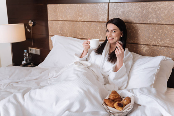 Woman eating croissant in bed - Photo, Image