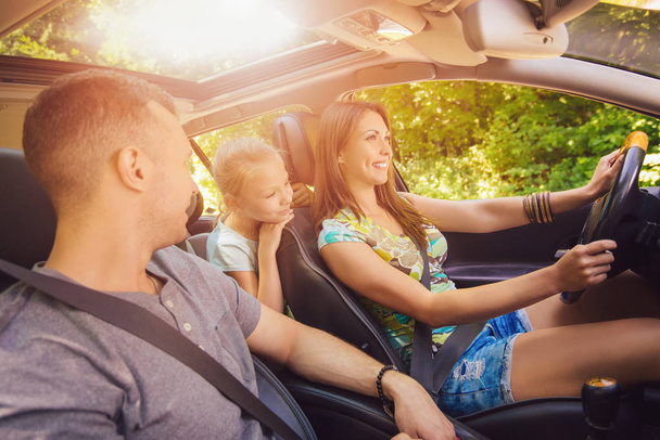 family of three enjoying at driving a car - Foto, imagen