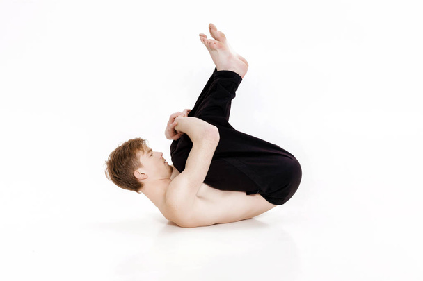 Young man doing yoga exercises. Studio shot on white background - Foto, Imagem