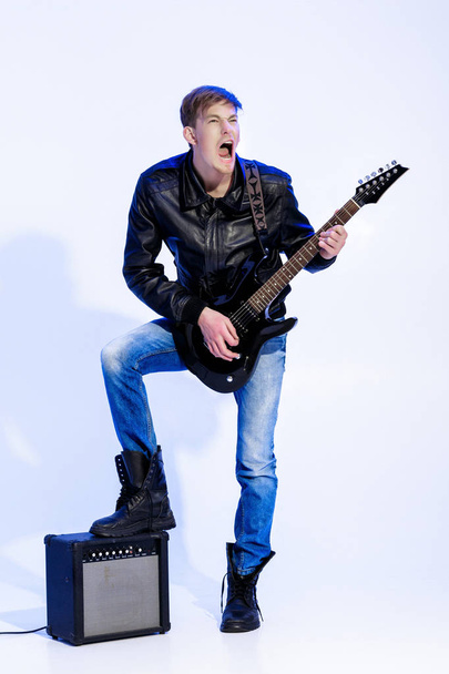 expressive handsome rock musician playing electric guitar and singing. Rock star - Фото, зображення