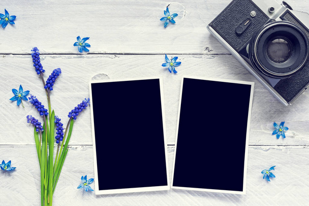 Vintage retro fényképezőgép, üres Fényképkeretek és kék tavaszi virágok - Fotó, kép