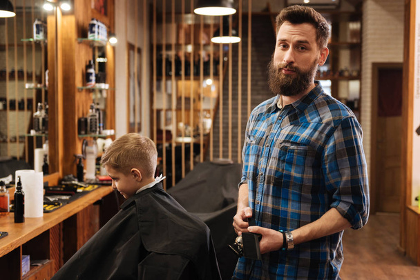 Nice good looking barber holding a comb - Photo, Image
